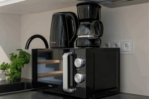 The kitchenette with a coffee machine, kettle, and microwave makes preparing drinks and meals a breeze.