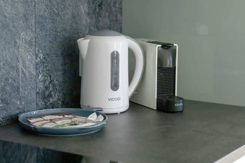lose-up of electric kettle and coffee machine in the kitchenette highlights functionality and modernity.