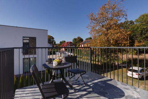 Another balcony angle showcasing a larger outdoor dining area with a scenic view of the surrounding greenery.