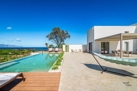 Lounge by the pool with uninterrupted views of Sicily’s breathtaking coastline.