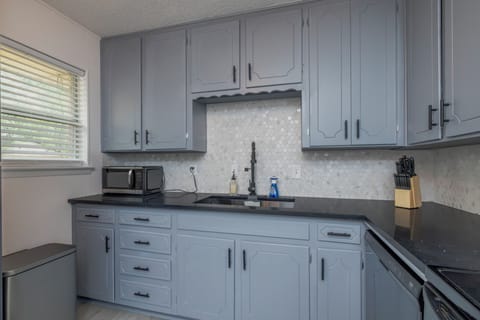 Fully stocked kitchen with a stainless steel range hood and cooking essentials.