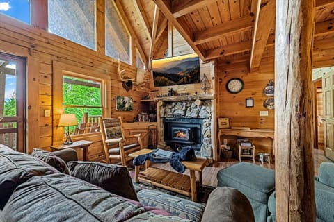 A stone fireplace with a flat-screen TV above creates the heart of the cabin — perfect for gathering with loved ones after a day of mountain adventures.