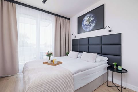 Lounge room with double bed, Smart TV and access to furnished balcony. 
