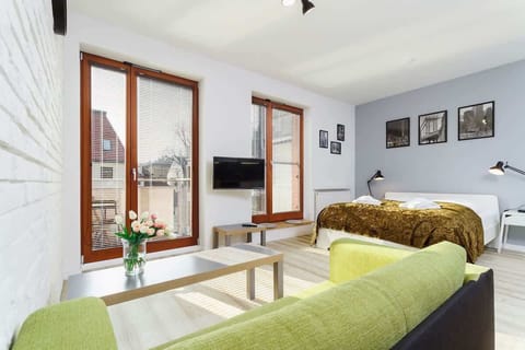 A bright living area combined with a bedroom area with a double bed. 