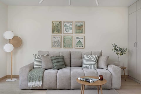 A second view of the bedroom featuring a sectional sofa and stylish artwork above.