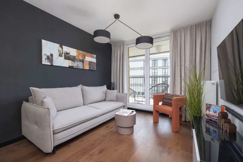 Atmospheric living room with a sofa, Smart TV and access to balcony.
