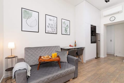 The living area features a sleek dining table and a flat-screen television.