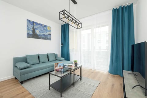 A different angle of the living room showcasing the turquoise curtains, sofa, and a vibrant, inviting ambiance.