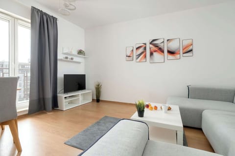 Comfortable living room with TV and balcony access – Airy and bright, perfect for relaxation or entertainment.