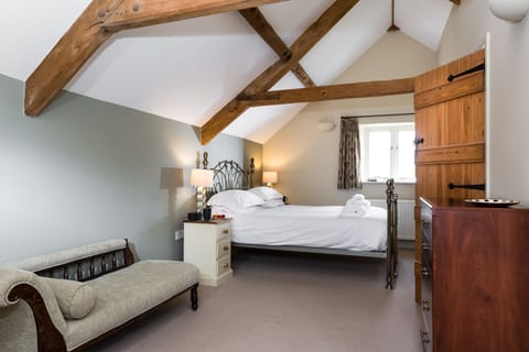 Bedroom one with a king-size bed, exposed beams and en-suite bathroom