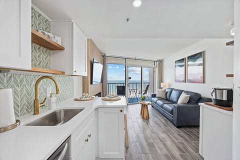Sleek modern kitchen flows into a cozy family room.