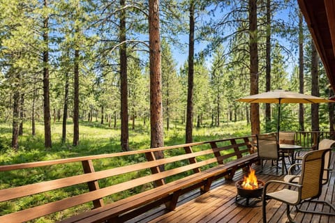 Your private deck overlooks towering pines and peaceful forest, with cozy seating around a crackling fire bowl for magical evenings under the stars.