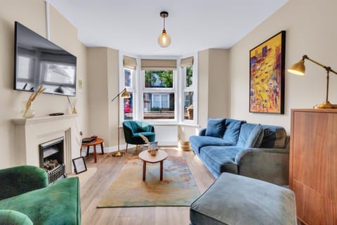 Cozy seating area with neutral-toned sofas and cushions, ideal for relaxation and streaming
