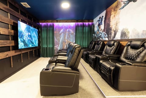 Experience a cinematic escape in our movie room, featuring comfortable black reclining seats for the best view. With a vibrant blue ceiling and chic decor, it's the perfect setting for memorable entertainment nights.