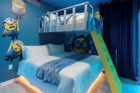 Bright blue walls and playful Minion murals make this children's bedroom a cheerful retreat, featuring a cozy double bed and a stylish lofted bunk, perfect for young guests to enjoy warm lighting and vibrant colors.