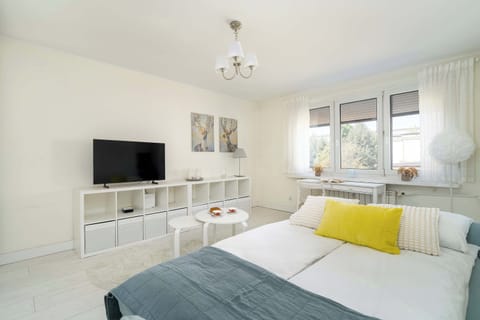 A bright interior with soft textiles and yellow accents creates a cozy space perfect for relaxing.