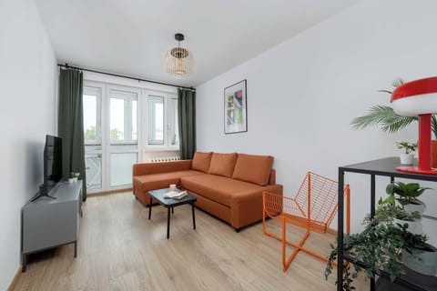 The stylish bedroom includes a comfortable sofa bed and a television.