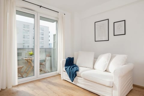Living room with a sofa bed, TV and exit to balcony.
