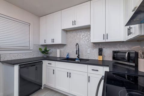 Fully stocked kitchen with a stainless steel range hood and cooking essentials.