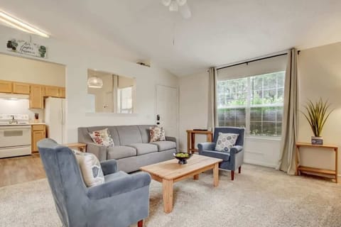 Cozy living room with comfortable seating and natural light from large windows.