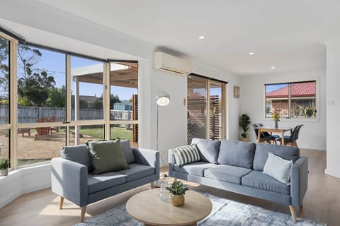 Bright, open-plan living and dining space with modern furnishings, reverse-cycle air conditioning, a