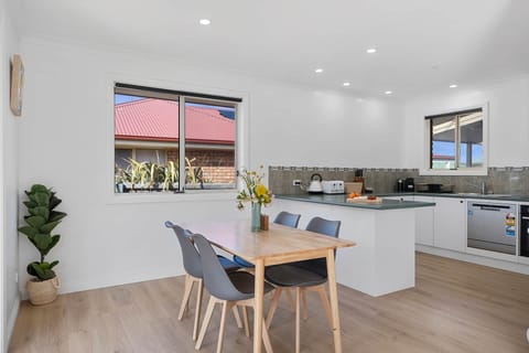 Bright, open kitchen & dining area with modern appliances, ample counter space, and a fresh, airy fe