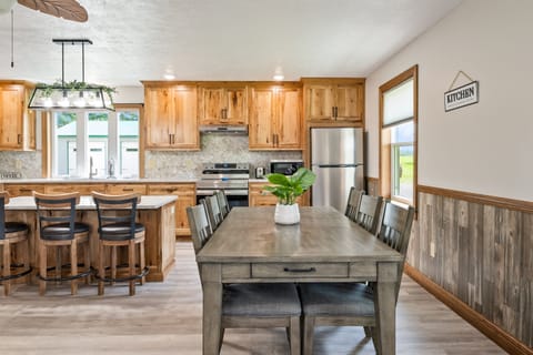 Enjoy meals with a view in this bright dining area featuring large windows, rustic wood accents, and cozy seating for six.