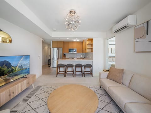 Living Room - Enjoy the open design of this Sky Ala Moana unit's living space, where a sofa and smart TV complement the breakfast bar. A comfortable setting to relax, dine, and unwind in Honolulu while you prepare to explore the rest Oahu.