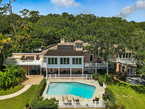 The Osprey Nest • Poolside View of Historic Estate - This St. Simons vacation rental sits on 2.5 private acres, with a marsh-facing gunite pool and original 1946 brick facade shaded by towering oaks. Welcome to The Osprey Nest—your luxury hideaway on the edge of history.