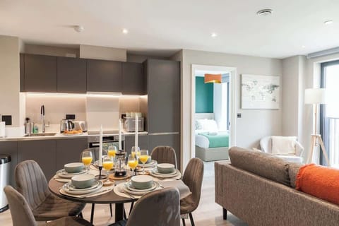A large dining table with six matching chairs sits at the center, offering ample seating for family and guests.
Positioned near a large window, the space is bathed in natural light, enhancing the room’s open and airy feel.