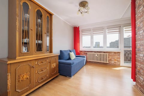 Bright and spacious studio with comfortable sofa, dining area, large windows, and plenty of natural light.
