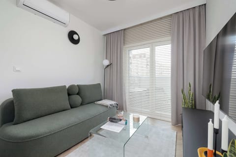 The elegant living room featuring a comfortable olive-green sofa perfect for relaxation.