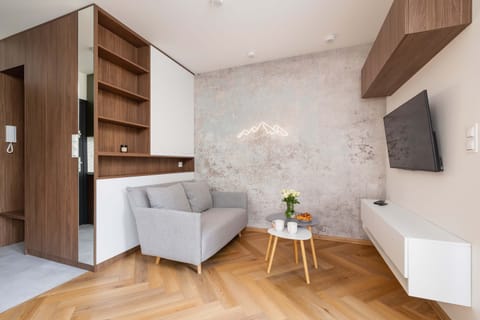 A cozy living room with a comfortable sofa and a view of the greenery outside. Perfect for relaxing or watching TV.