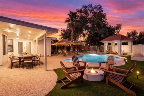 Resort-style backyard with a sparkling pool, sun loungers, outdoor dining area, grill, a cozy fire pit with surrounding seating, sauna, cold plunge, and outdoor shower.