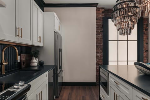 While fully equipped with modern conveniences, the kitchen retains the building’s historic charm with its original exposed brick walls.