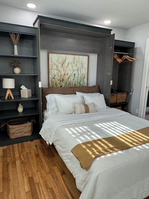 Queen size bed with ample lighting and linens. 