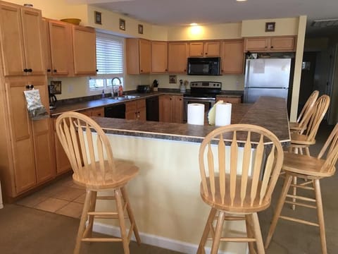 The kitchen showcases ample cabinetry and modern appliances, complete with a convenient breakfast bar perfect for casual meals.