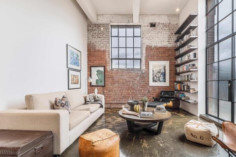 LOUNGE/LIVING: Where raw textures meet refined design. Unwind beneath soaring ceilings, bask in natural light and let the space speak for itself.