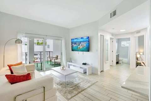 Spacious living room with cozy seating and a 65" smart TV, perfect for movie nights or relaxing after a day out.