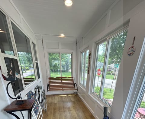 Sunroom with porch swing overlooks corner of Peach and 5th Ave
