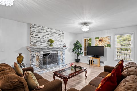 Living Room 1 | Stone fireplace, flat-screen TV, and plush seating