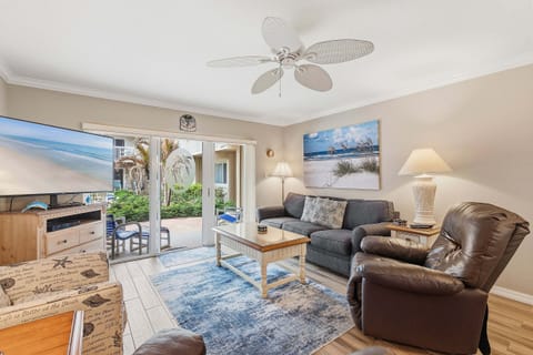Bright beach stay living space with comfy seating, coastal décor, and patio access. Relax after the beach with natural light, TV, and inviting vibes—perfect for your seaside vacation getaway.