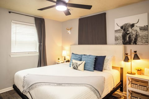 Primary bedroom with king bed, large smart tv, and en suite bathroom.