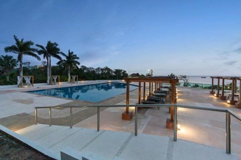 A large ocean view pool is surrounded by reclining loungers, ideal for daytime sun and relaxation.