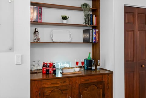 Gather, laugh, and compete in this open-concept game room featuring vintage decor, a stocked game bar, and indoor-outdoor flow straight to the pool area.