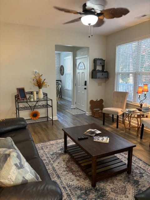 Comfortable Den with tall windows, reclining couch, TV and gas fireplace.