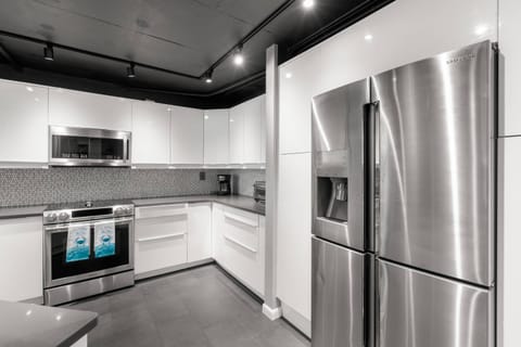 Updated, Fully Equipped Kitchen with Sleek White Cabinets and Stainless-Steel Appliances