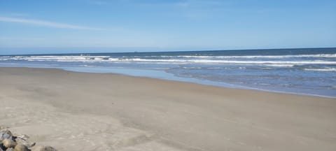On the beach, sun loungers, beach umbrellas, windsurfing