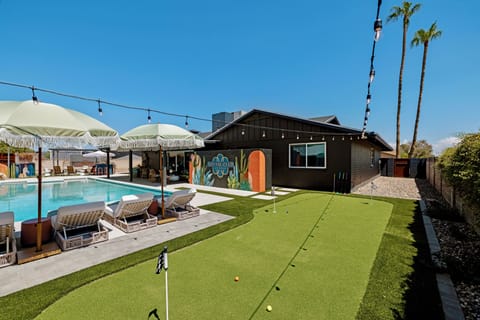 Putting green overlooking the pool loungers and sparkling pool.