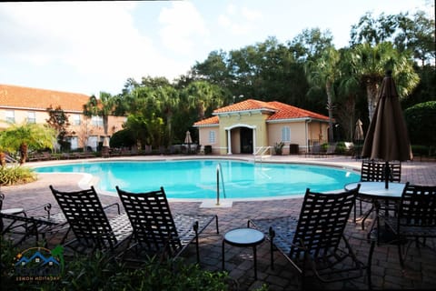 Relax in resort style at our clubhouse pool, surrounded by lounge chairs, umbrellas, and tropical foliage—an inviting oasis day or twilight.